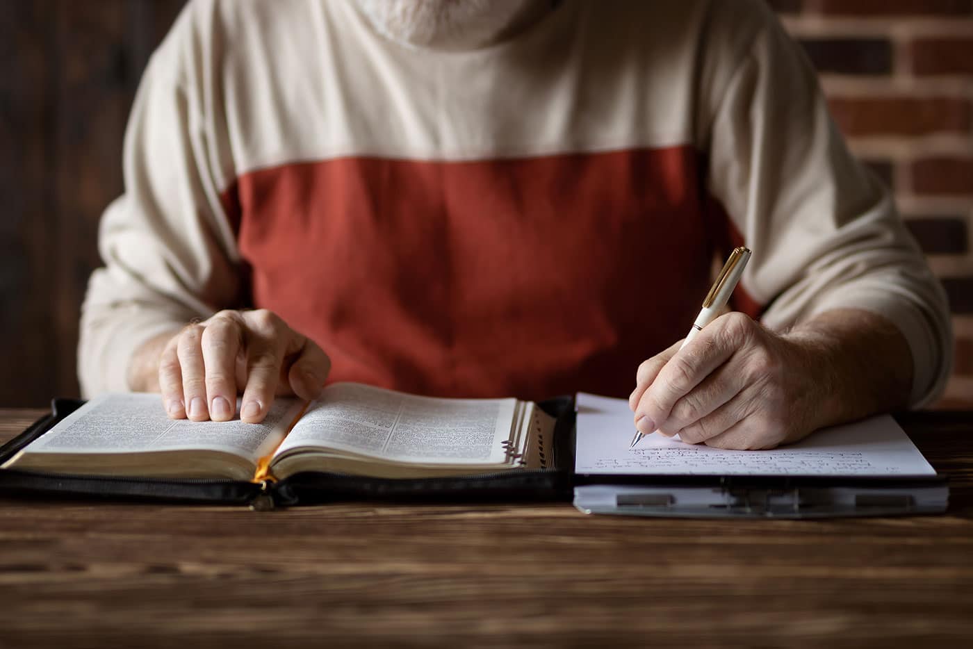Man taking notes while reading the Bible